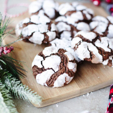 chocolate crinkle cookies lined up on a wood serving board.