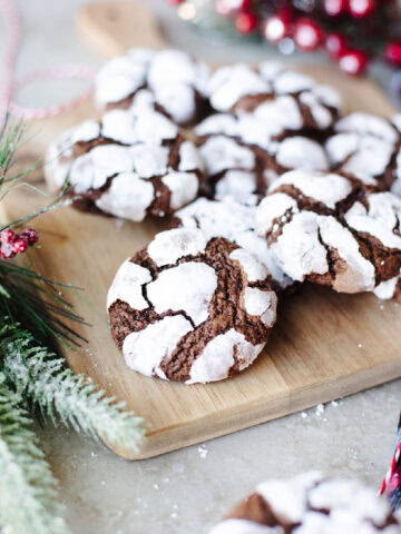 chocolate crinkle cookies lined up on a wood serving board.