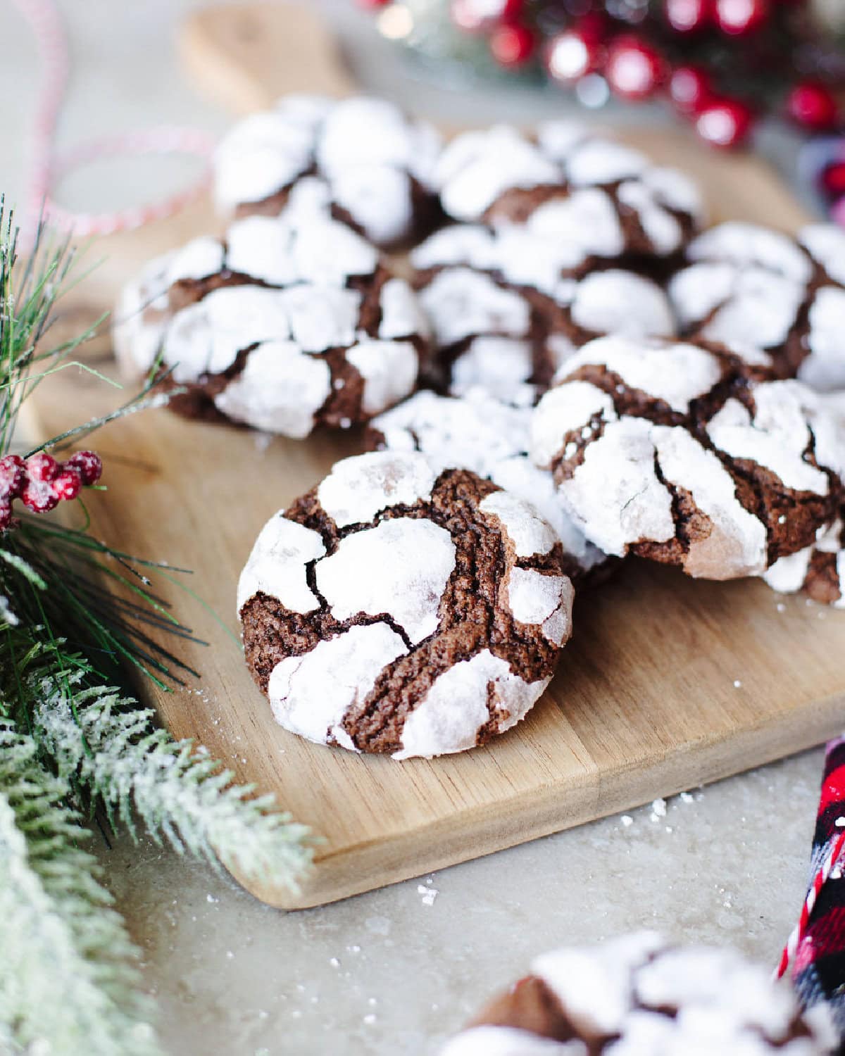 chocolate crinkle cookies lined up on a wood serving board.