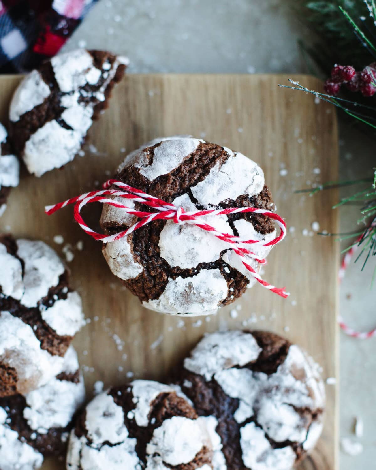 a stack of Hershey Crinkle Cookies tied with a ribbon on a wood board.