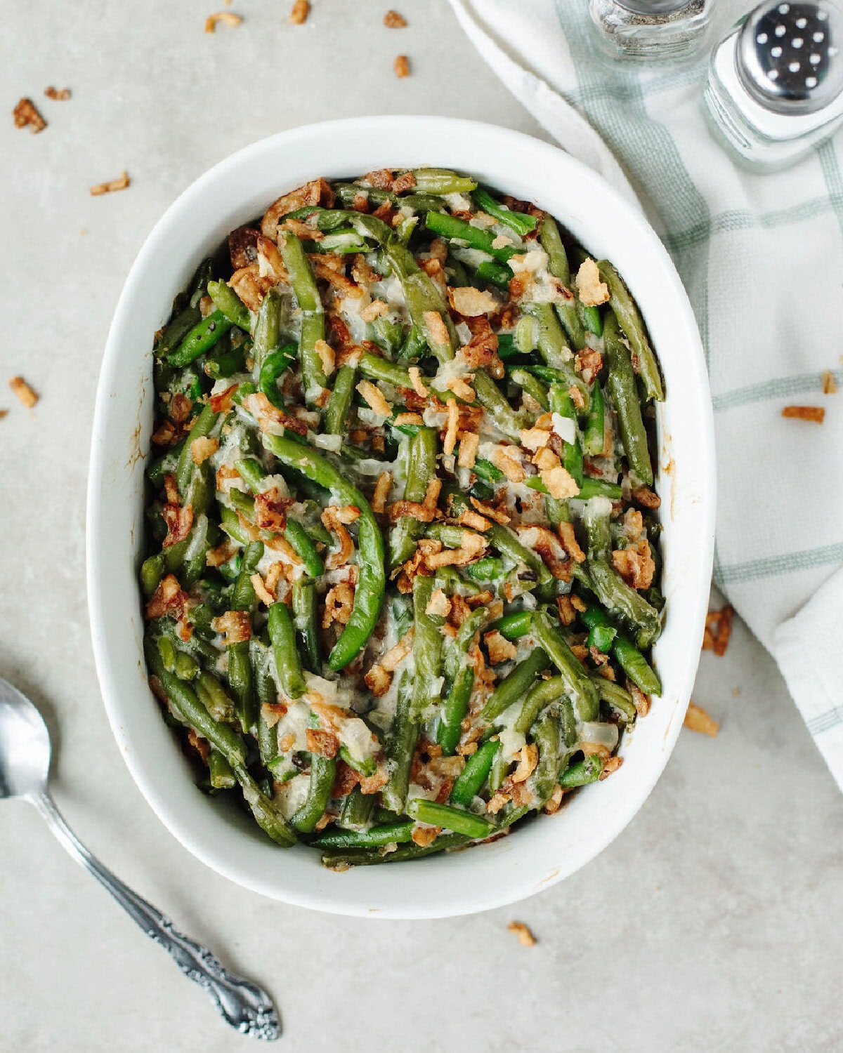 French fried onions on top of Campbells green bean casserole in a white baking dish.