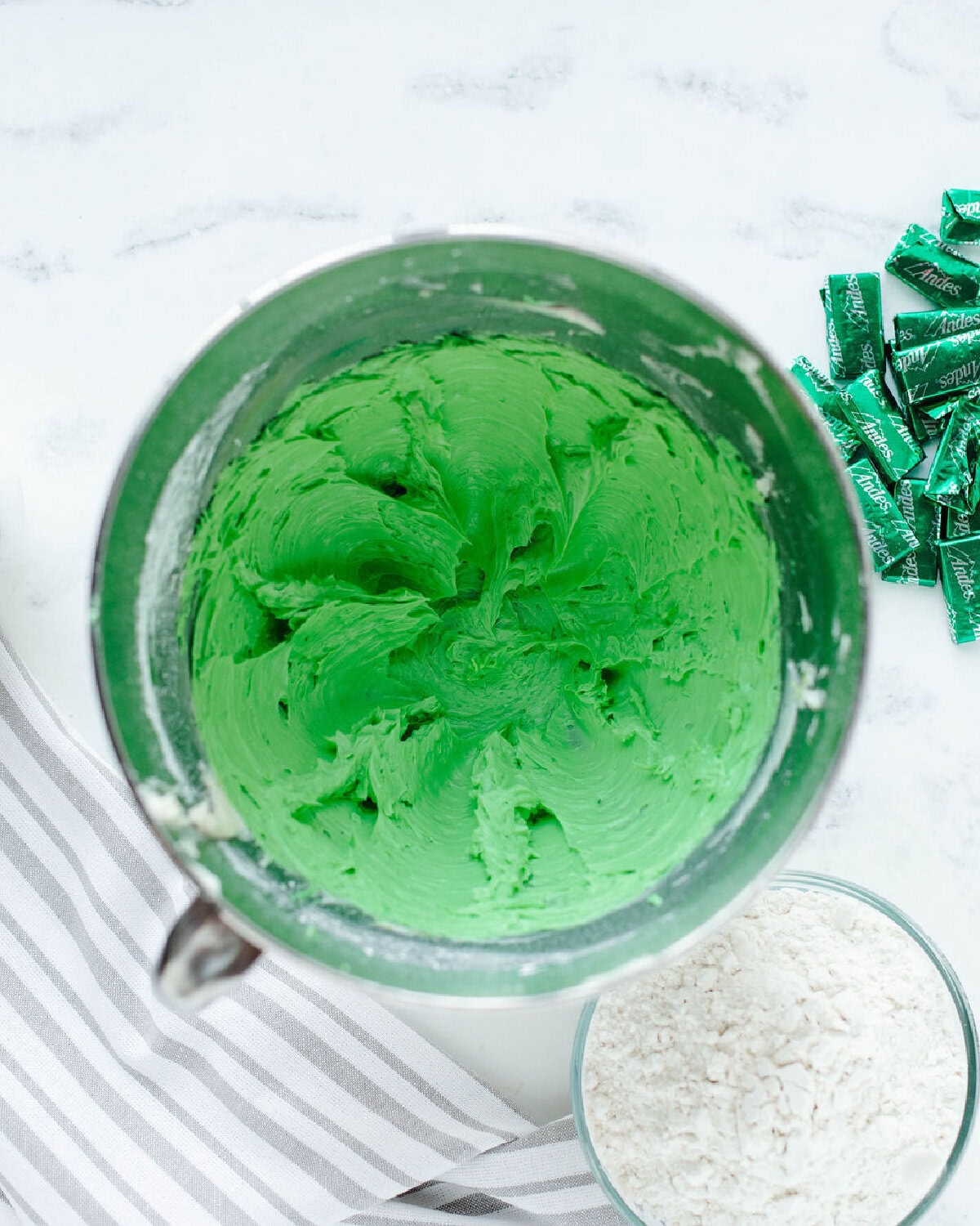 dry ingredients added to a cookie dough mixture in a mixing bowl.