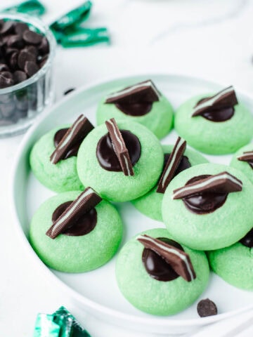 melted dark chocolate and an andes mint in the center of a mint thumbprint cookie.