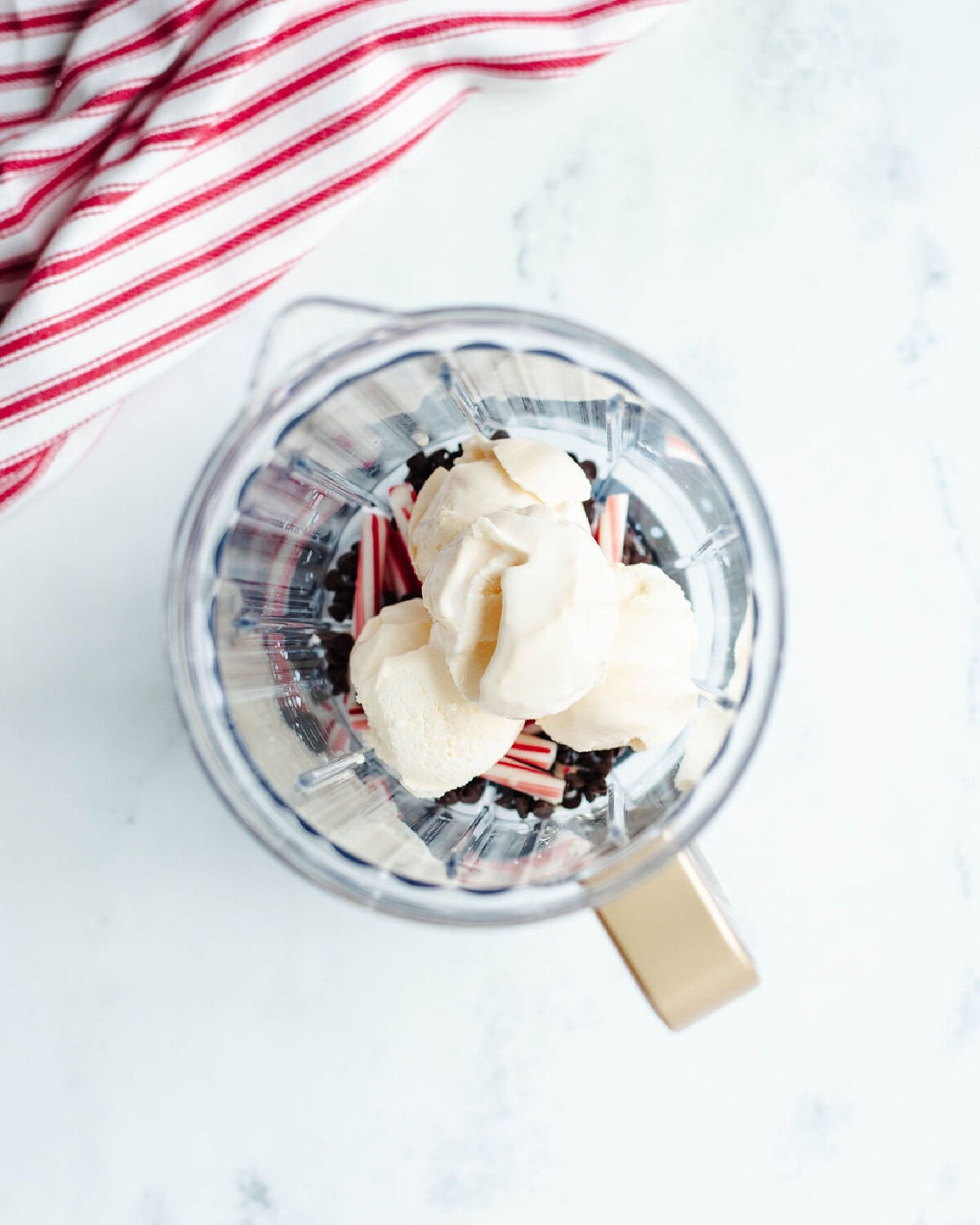 vanilla ice cream added to a blender to make a milkshake.