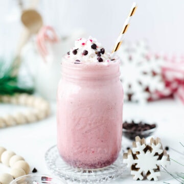 a copycat chick fil a peppermint milkshake in a mug with whipped cream and mini chocolate chips.