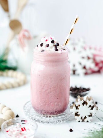 a copycat chick fil a peppermint milkshake in a mug with whipped cream and mini chocolate chips.