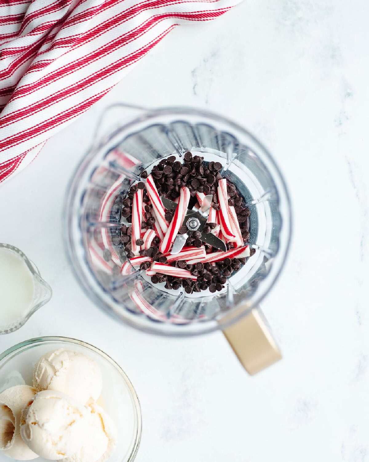 broken candy cane pieces, chocolate chips, and ice cream in a blender.