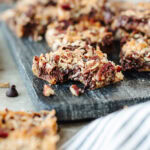Eagle Brand Magic Cookie Bars sliced on a platter and a bite taken out of one.