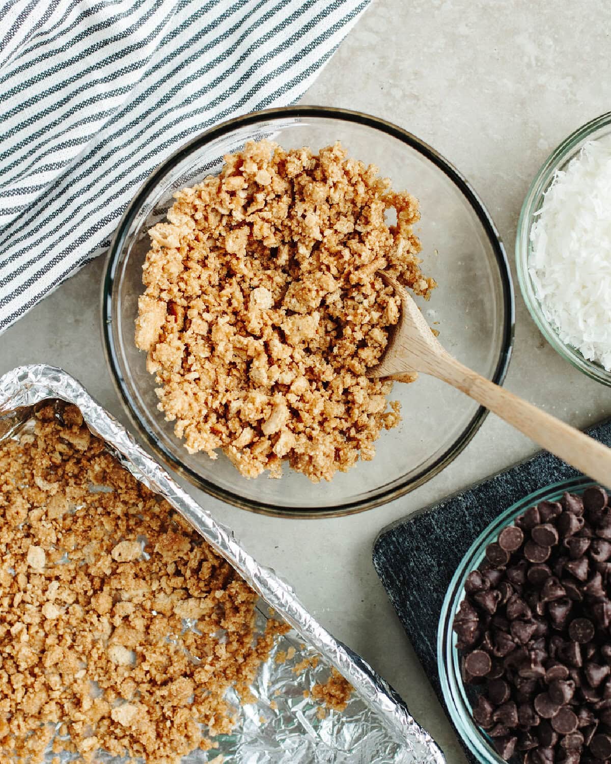 graham cracker crumbs and melted butter combined in a glass mixing bowl.