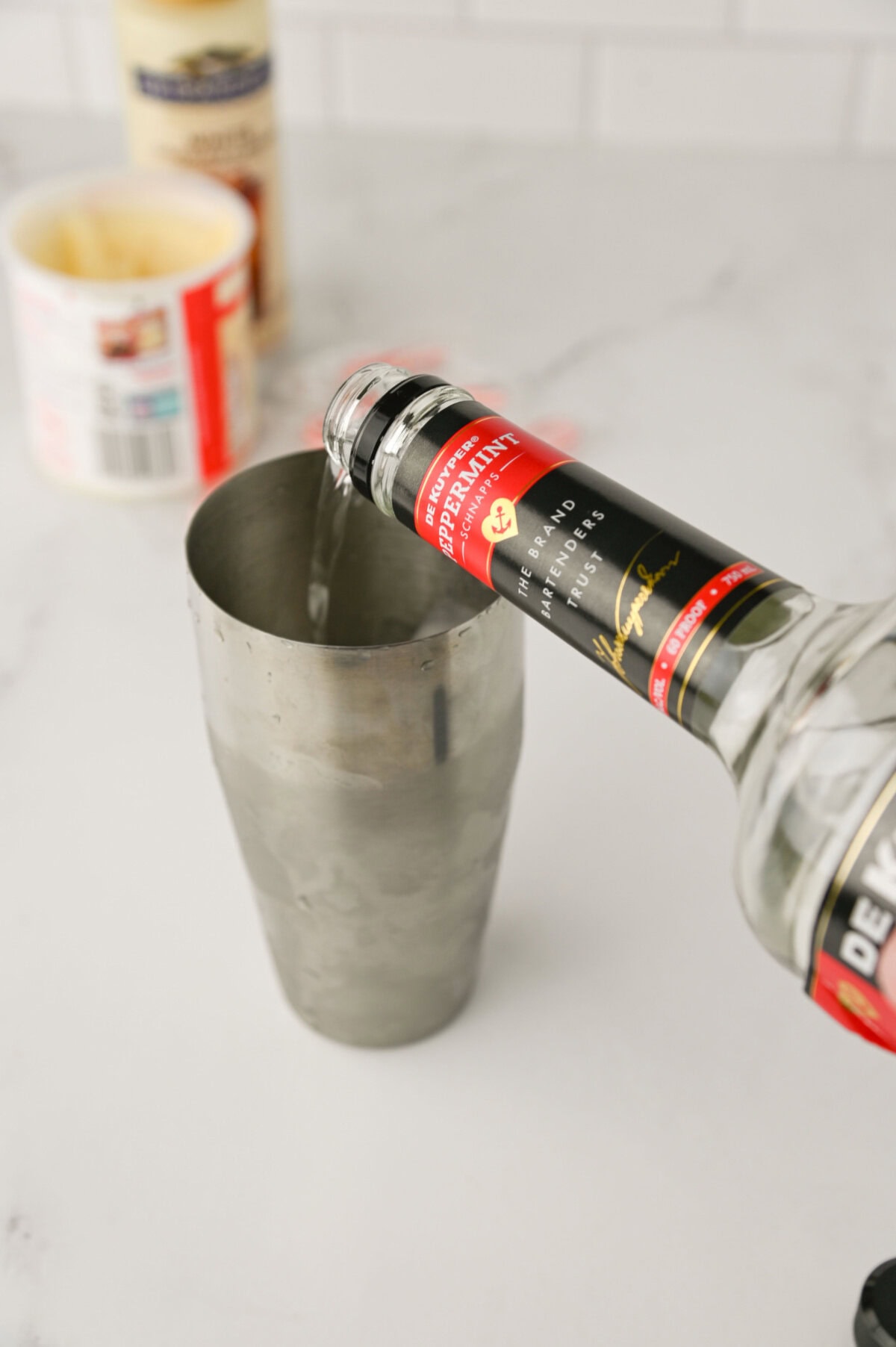 peppermint schnapps poured into a cocktail shaker.