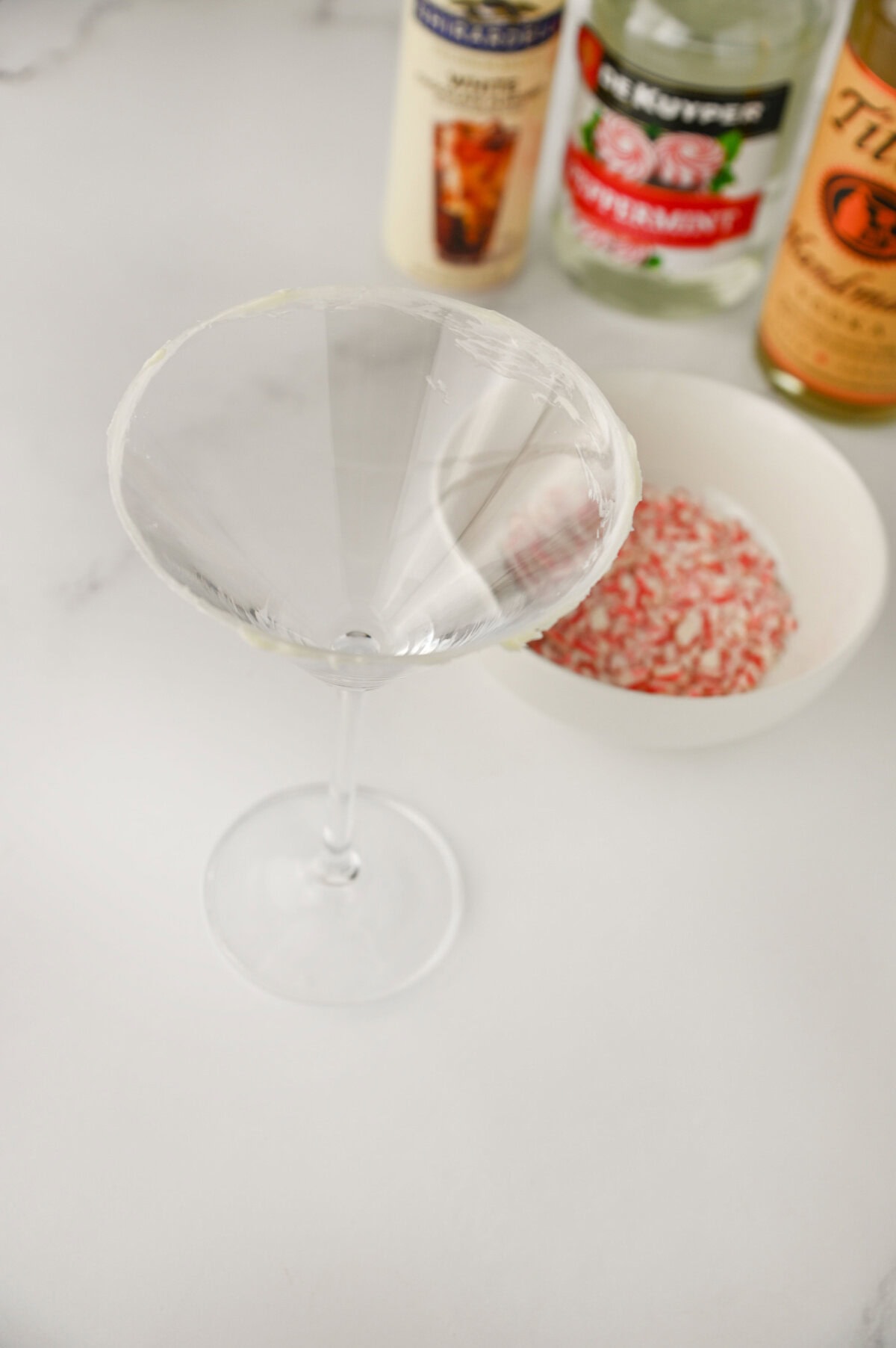 frosting rimming a martini glass to hold crushed candy cane.