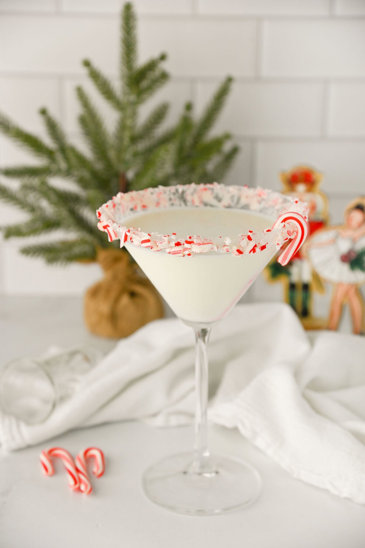 a candy cane rimmed white chocolate peppermint martini ready to serve.