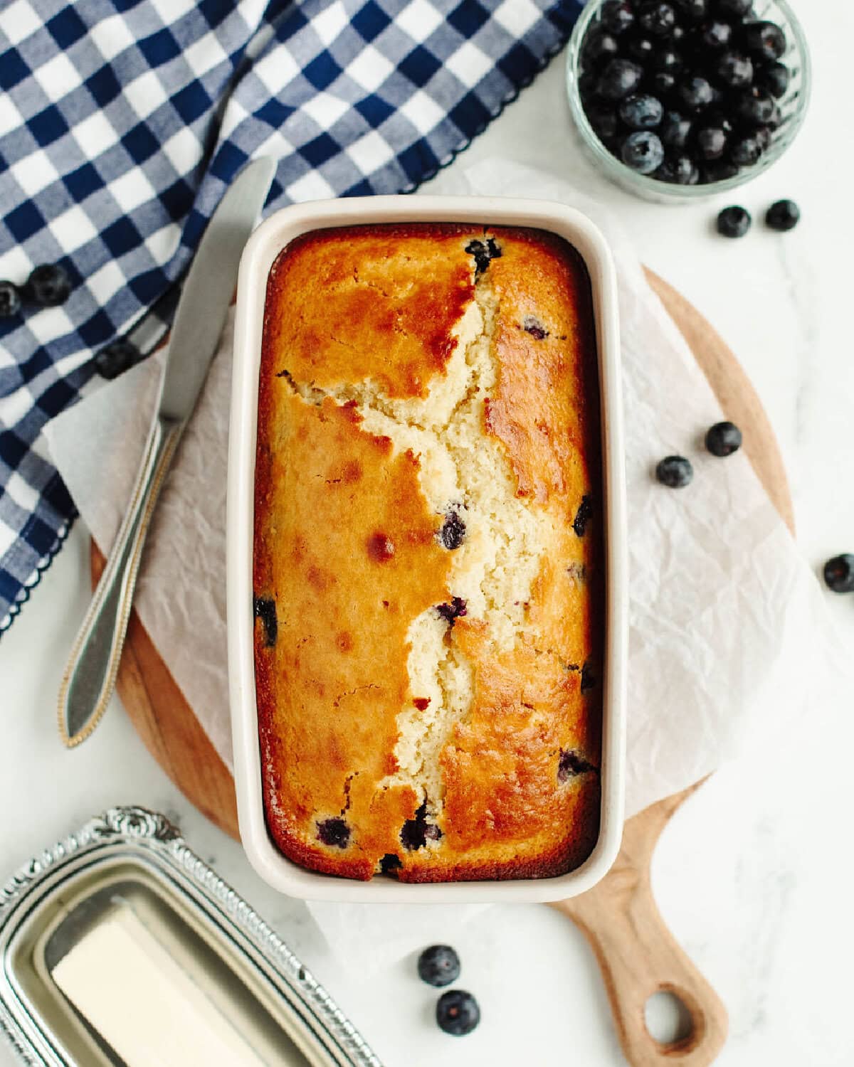 a baked loaf of blueberry bread fresh from the oven in a loaf pan.