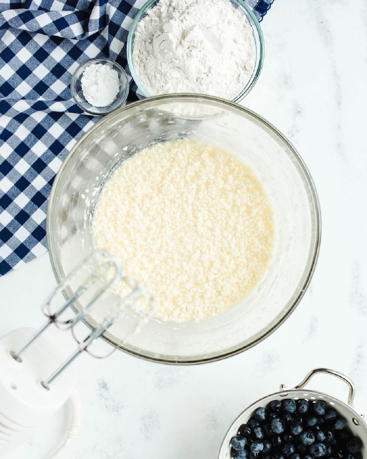 butter and sugar creamed together in a glass mixing bowl.