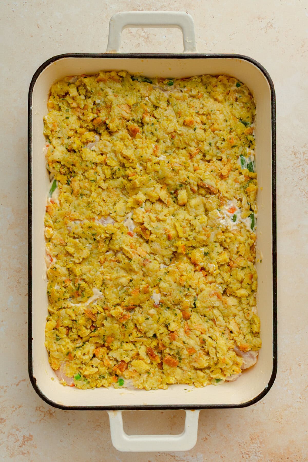 Stuffing spread over chicken mixture in a baking dish.