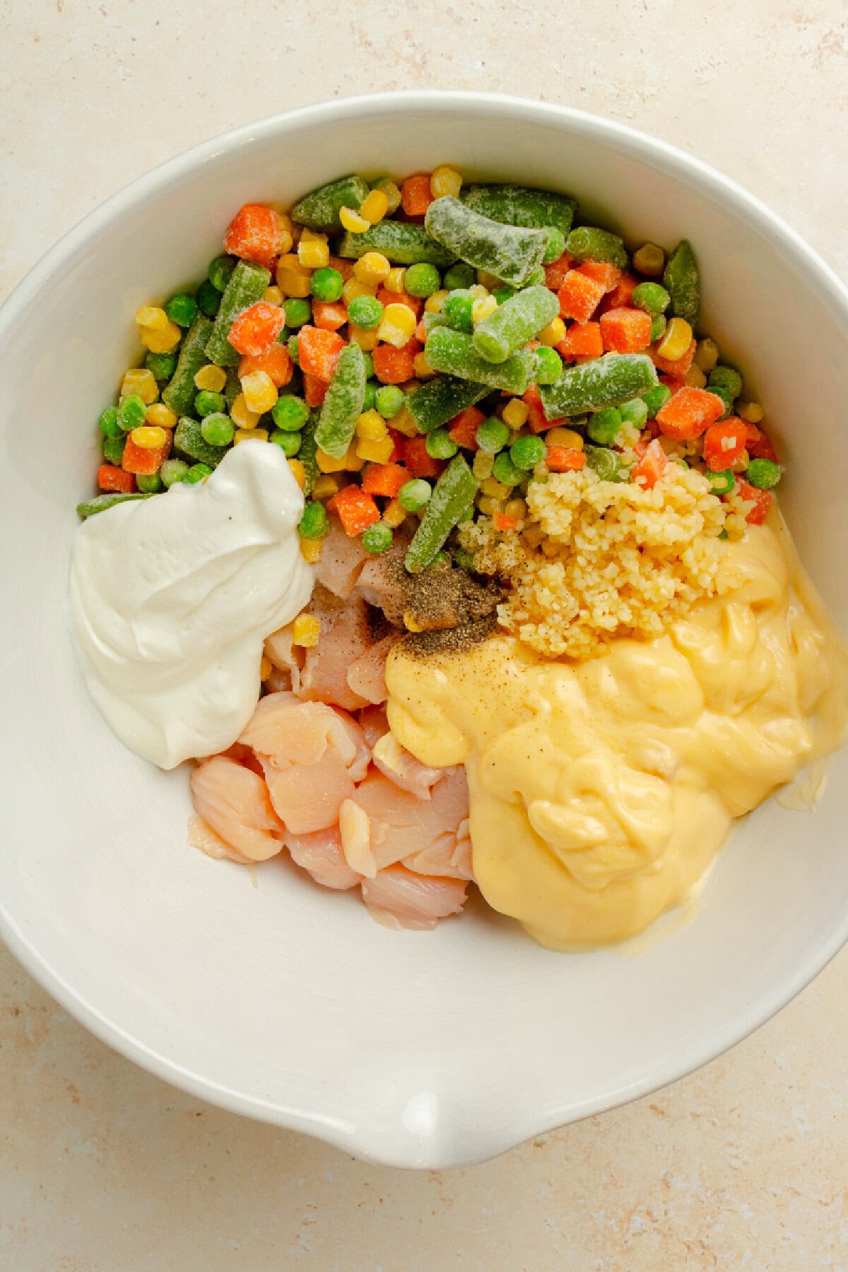 Diced chicken mixed with cream of chicken soup, sour cream, and vegetables for casserole.