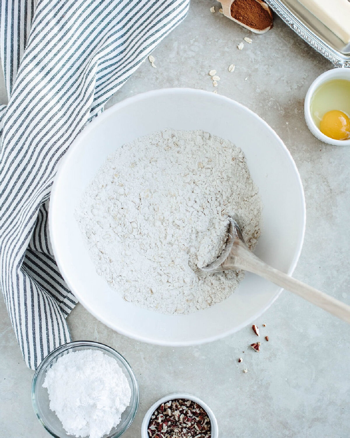 flour, oats, baking powder, and salt combined in a white mixing bowl.