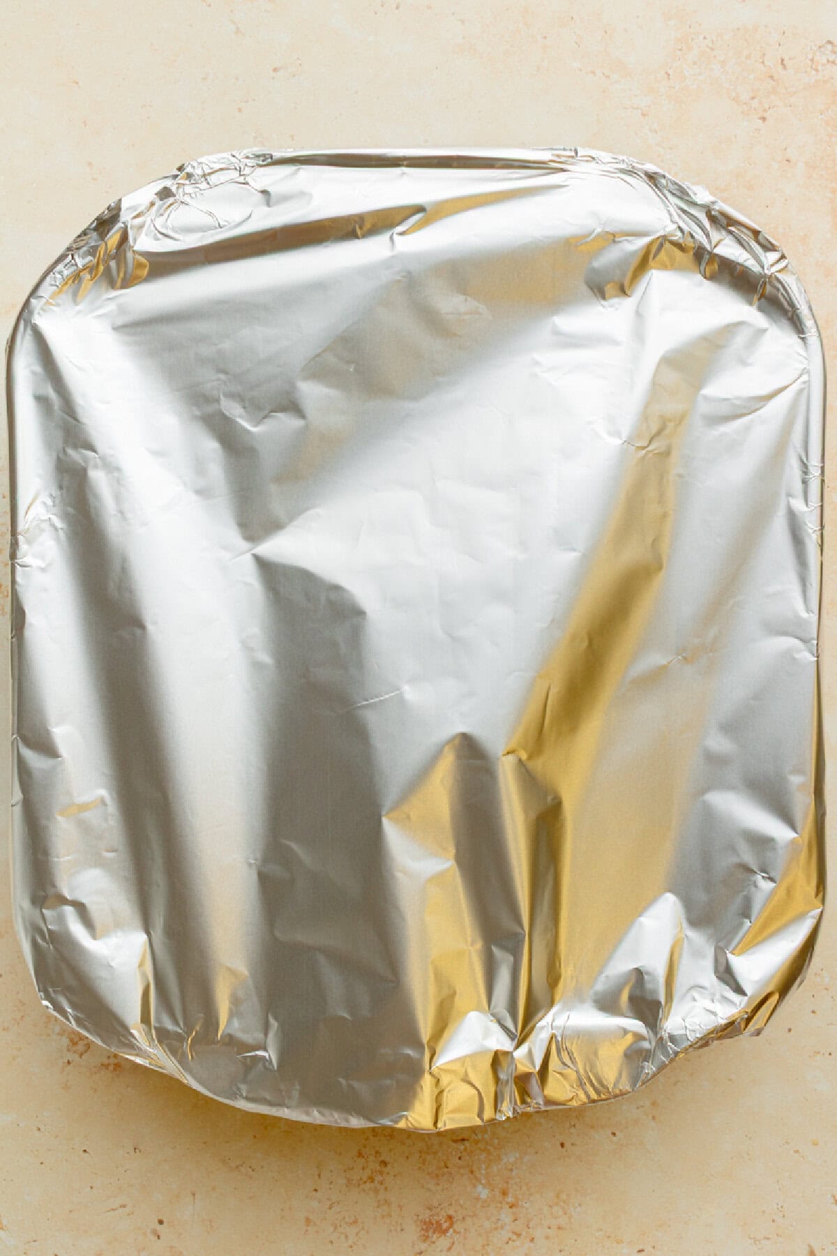 aluminum foil covering an 8x8 glass baking dish.