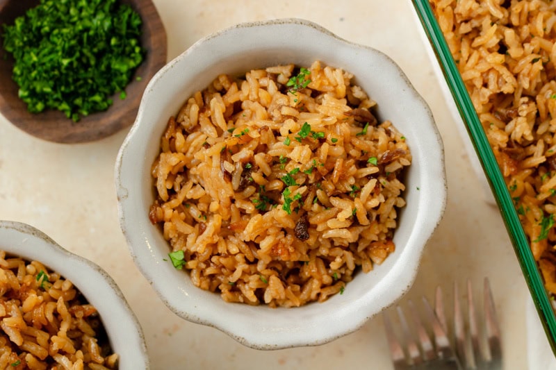 a small white serving bowl of French Onion Soup Rice ready to enjoy.