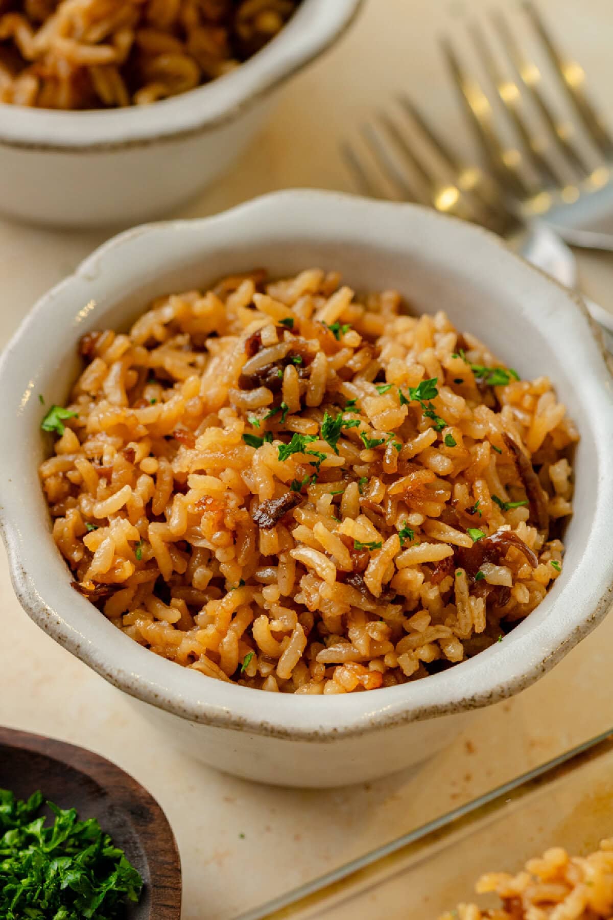 a white serving bowl with a scoop of stick of butter rice ready to enjoy.