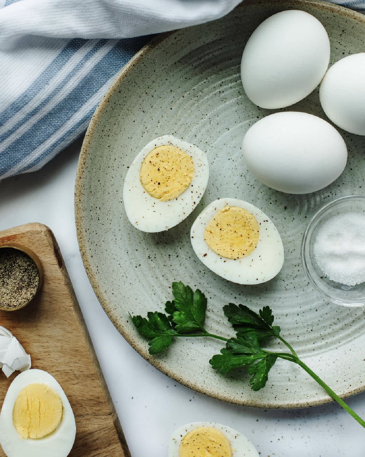 hard boiled eggs sliced in half on a plate and sprinkled with seasoning.