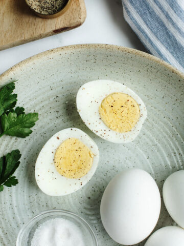 instant pot hard boiled eggs sliced in half on a plate with seasoning.