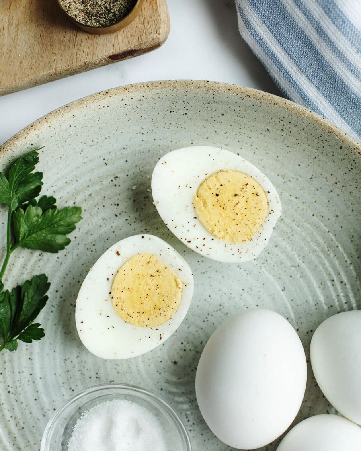 instant pot hard boiled eggs sliced in half on a plate with seasoning.