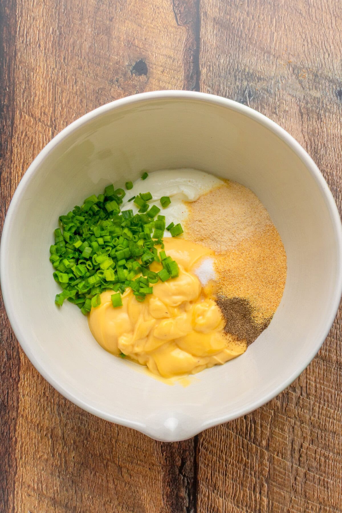 Mixing creamy sauce mixture together in a mixing bowl for the chicken casserole.