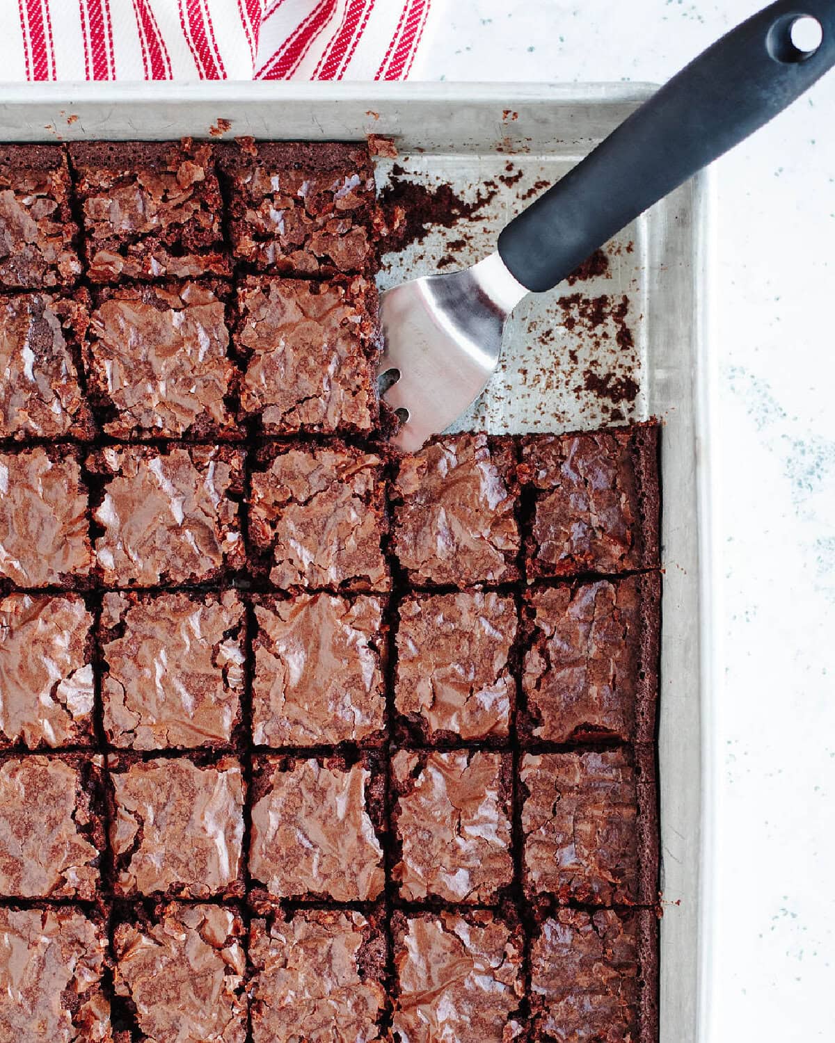 Baked brownies cut into small pieces in a baking pan.