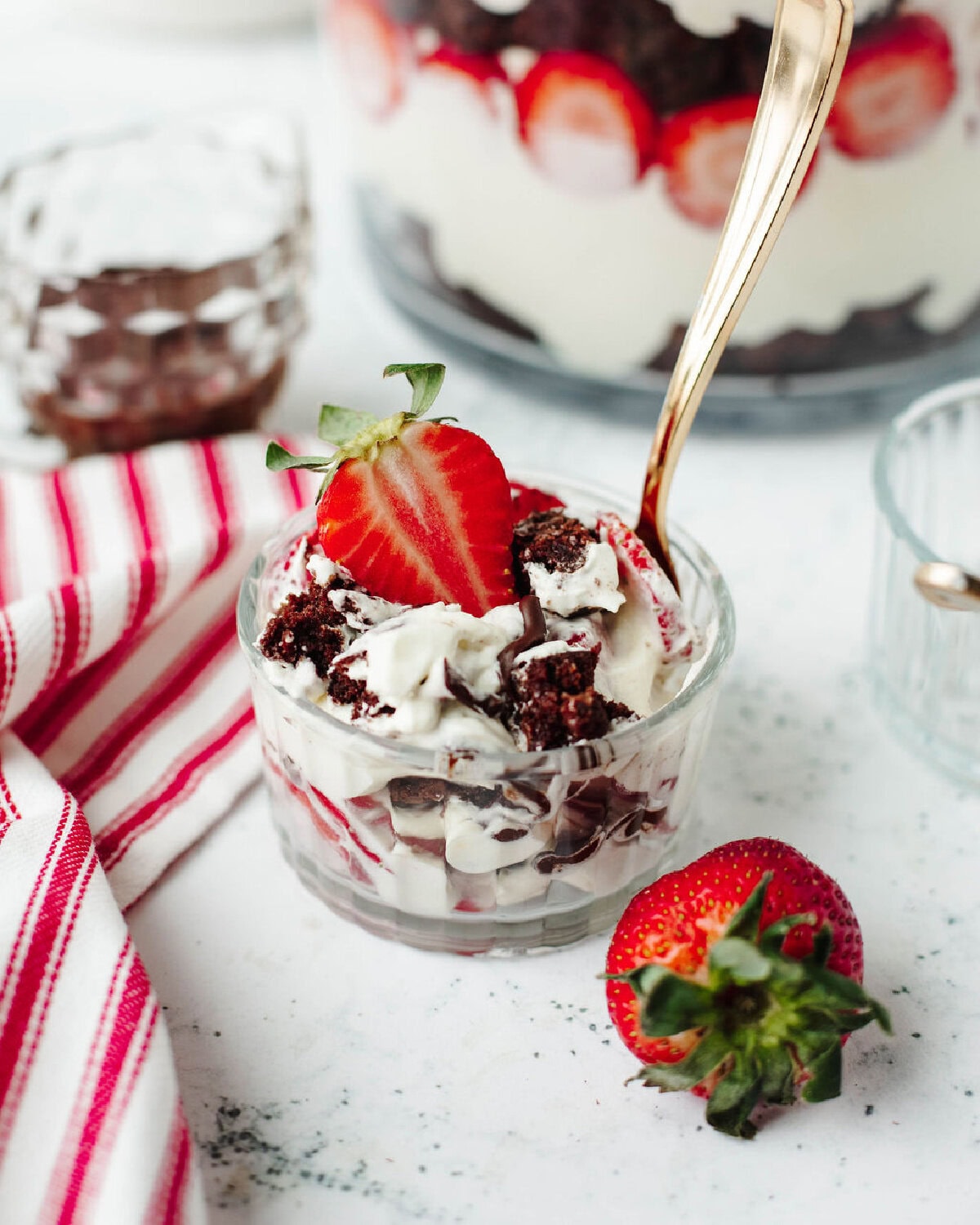 A small parfait bowl with a scoop of strawberry brownie trifle ready to serve.