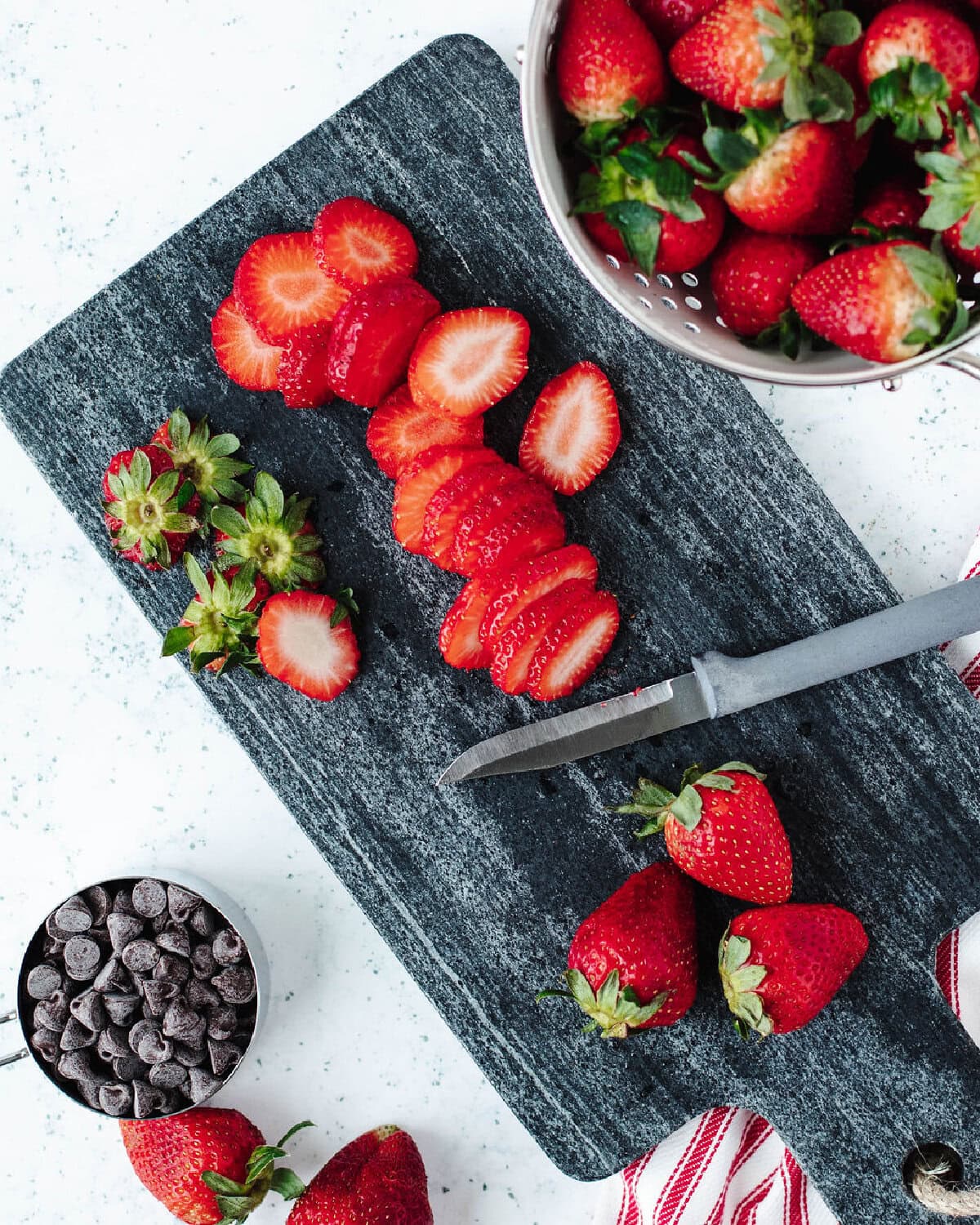 Sliced strawberries on a cutting board.