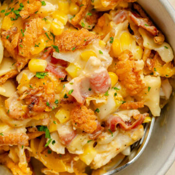 A serving bowl showing the baked casserole with chicken, bacon, corn, and a creamy sauce.