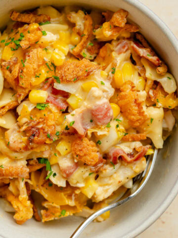 A serving bowl showing the baked casserole with chicken, bacon, corn, and a creamy sauce.
