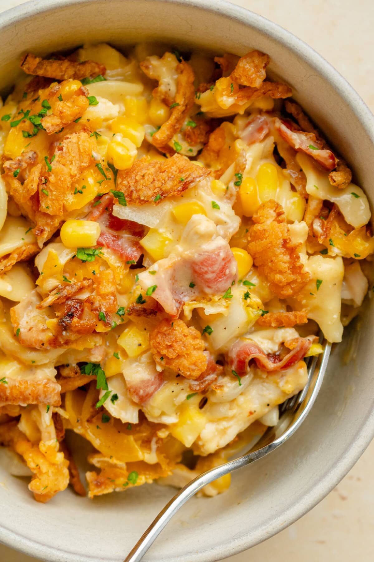 A serving bowl showing the baked casserole with chicken, bacon, corn, and a creamy sauce.