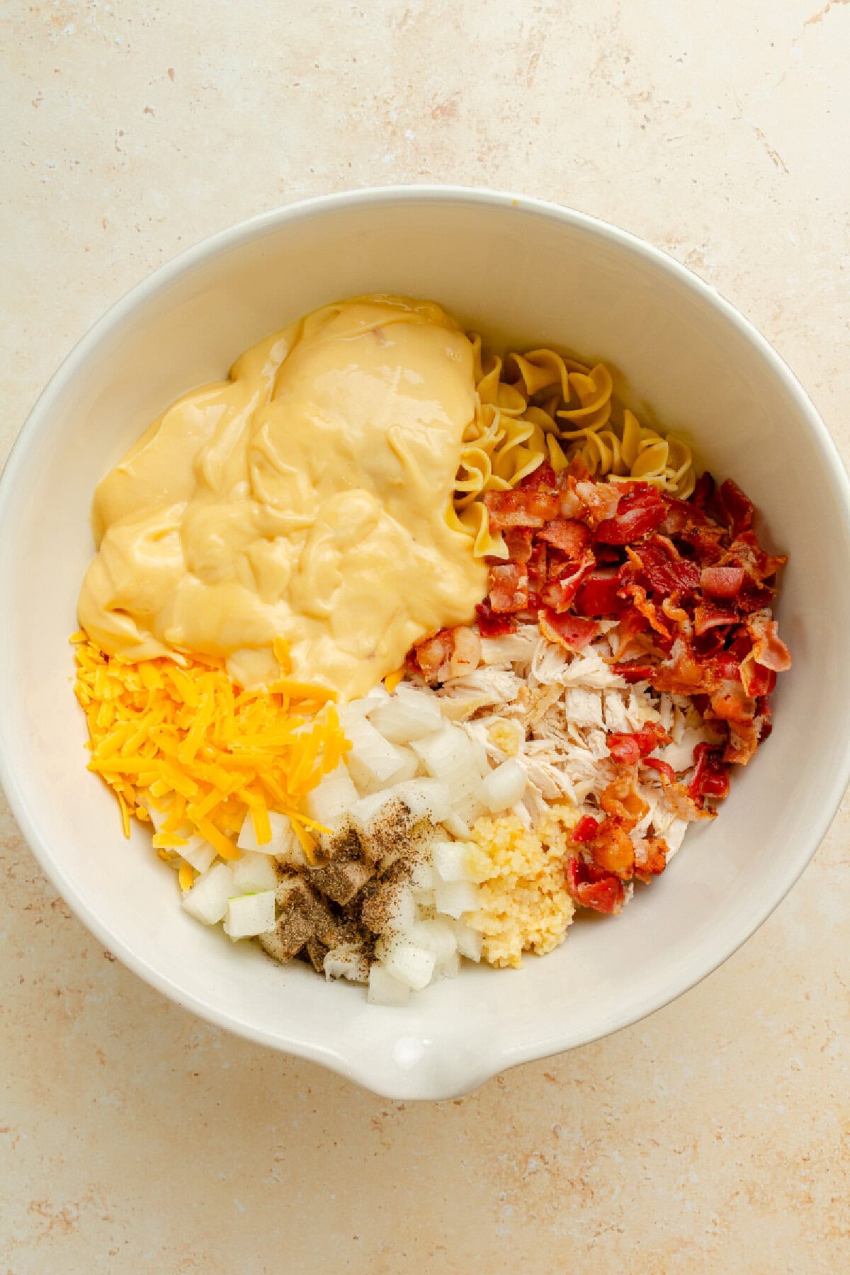 Creamy chicken casserole ingredients added to a mixing bowl.