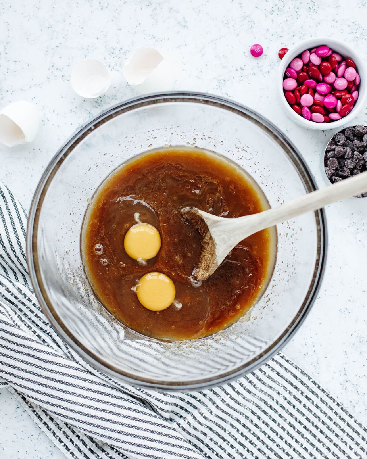 Melted butter combined with brown sugar and vanilla extract in a glass mixing bowl.