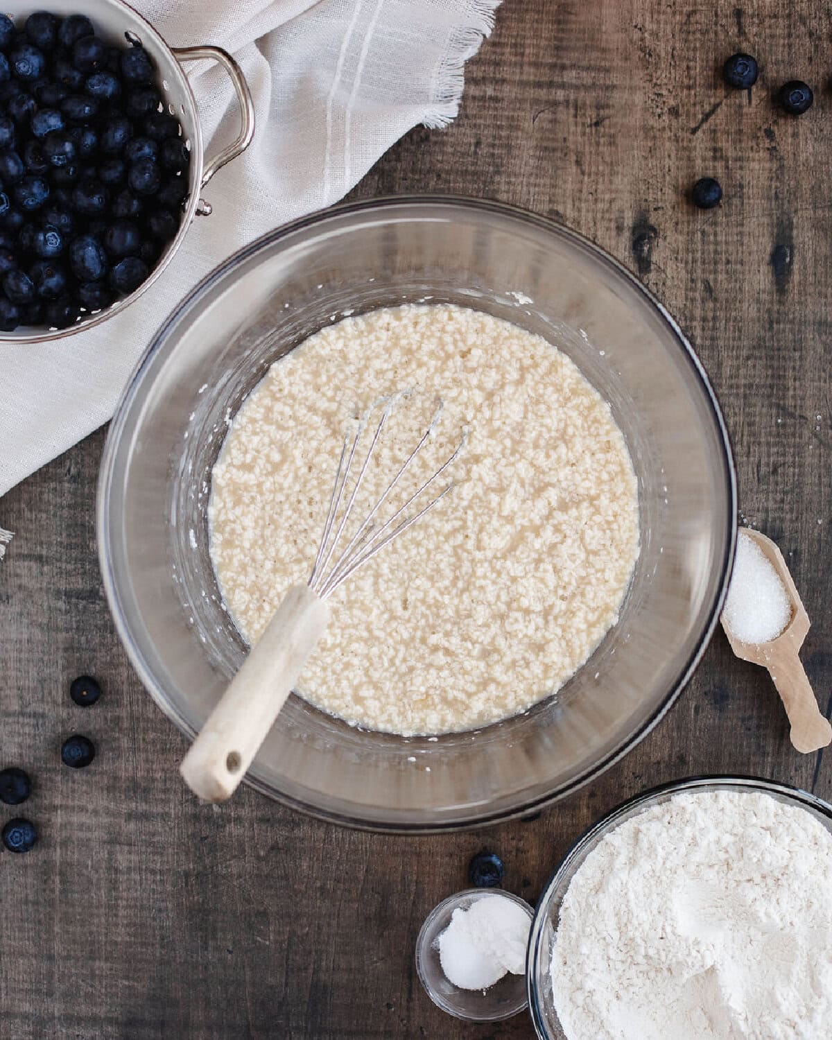 Butter, sugar, eggs, vanilla extract, and milk combined in a glass bowl.