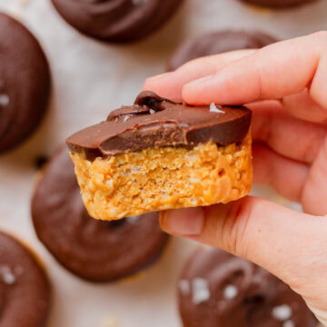 A bite taken out of a chocolate peanut butter rice krispy cup to show the center.