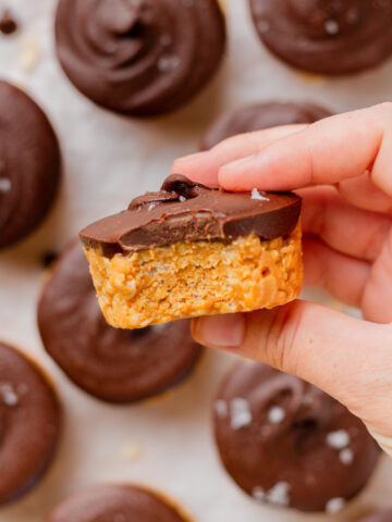 A bite taken out of a chocolate peanut butter rice krispy cup to show the center.