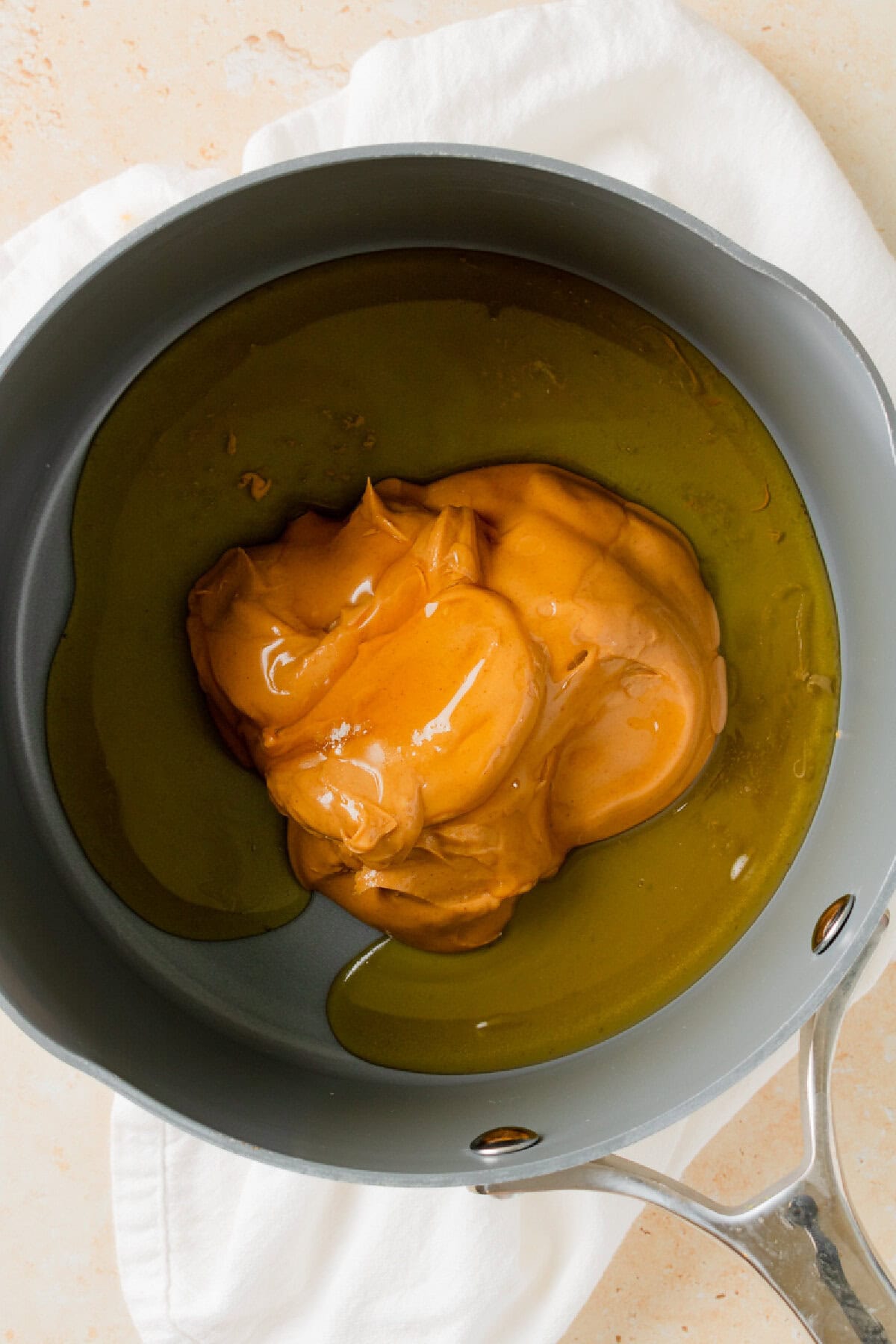 Creamy peanut butter and honey mixed together in a small saucepan.