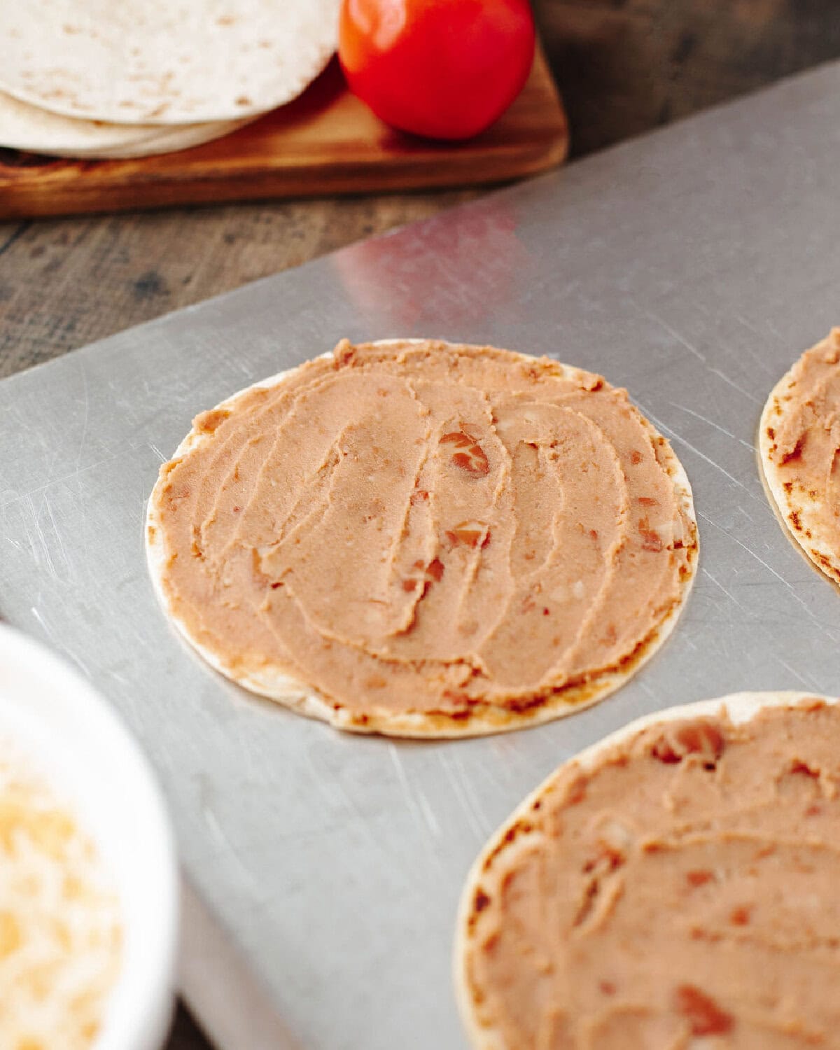 Refried beans spread onto a flour tortilla.
