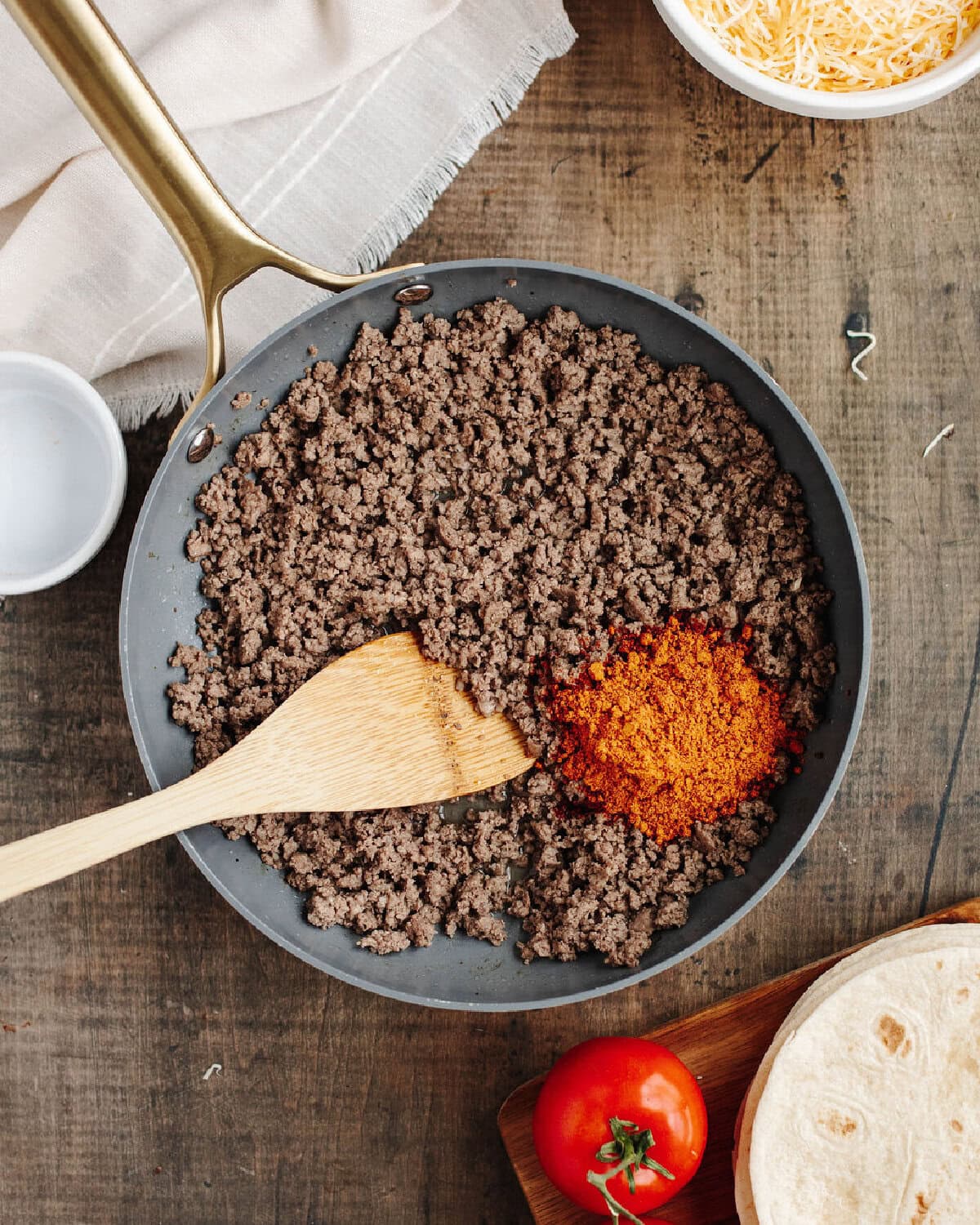 Ground beef cooking with taco seasoning for Mexican pizza filling.