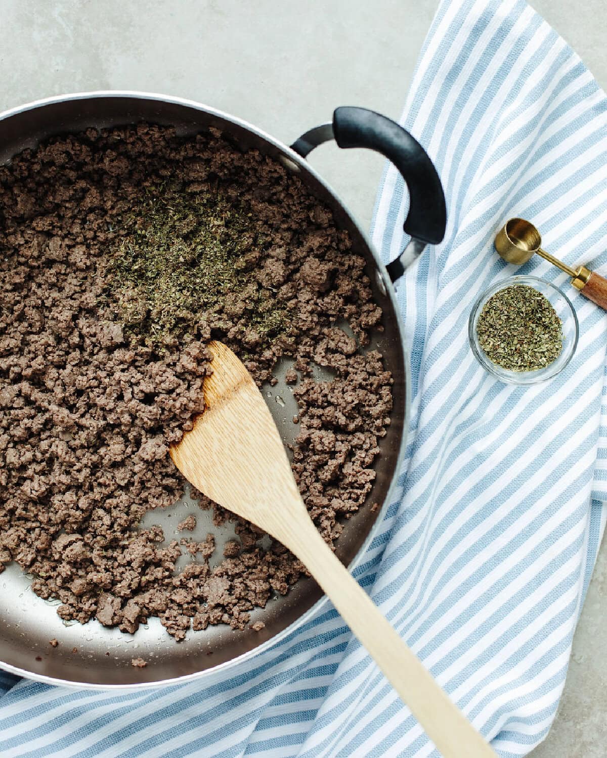 Ground beef cooked with Italian seasoning in a skillet.