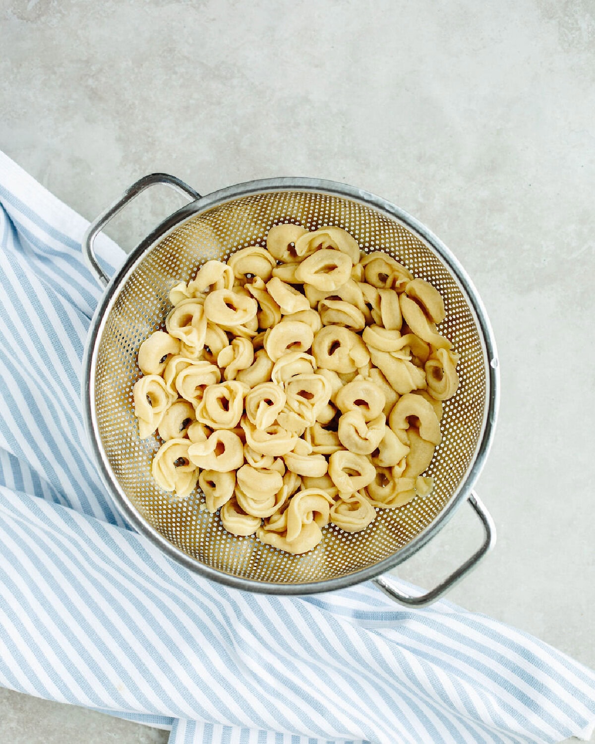 Tortellini cooked to package directions and drained of water using a strainer.