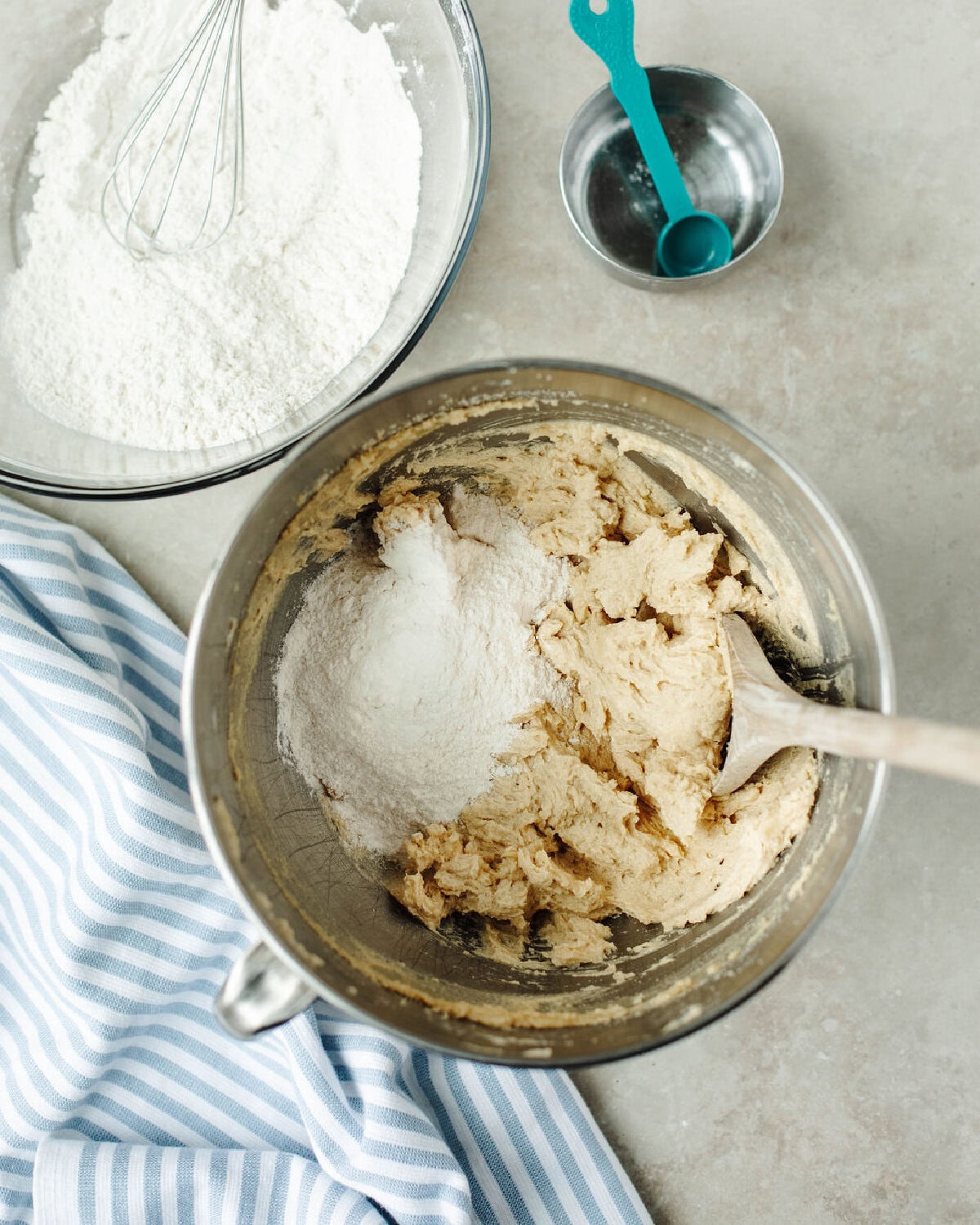 Flour being mixed into creamed butter and sugar in a mixing bowl.