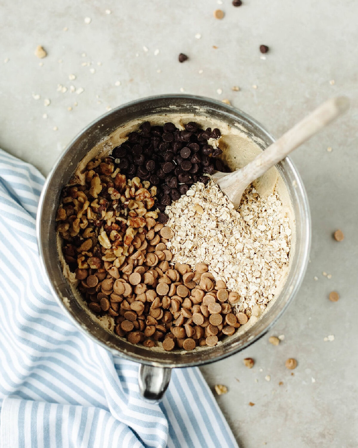 Oats, chocolate chips, peanut butter chips, and walnuts mixed into cookie dough.