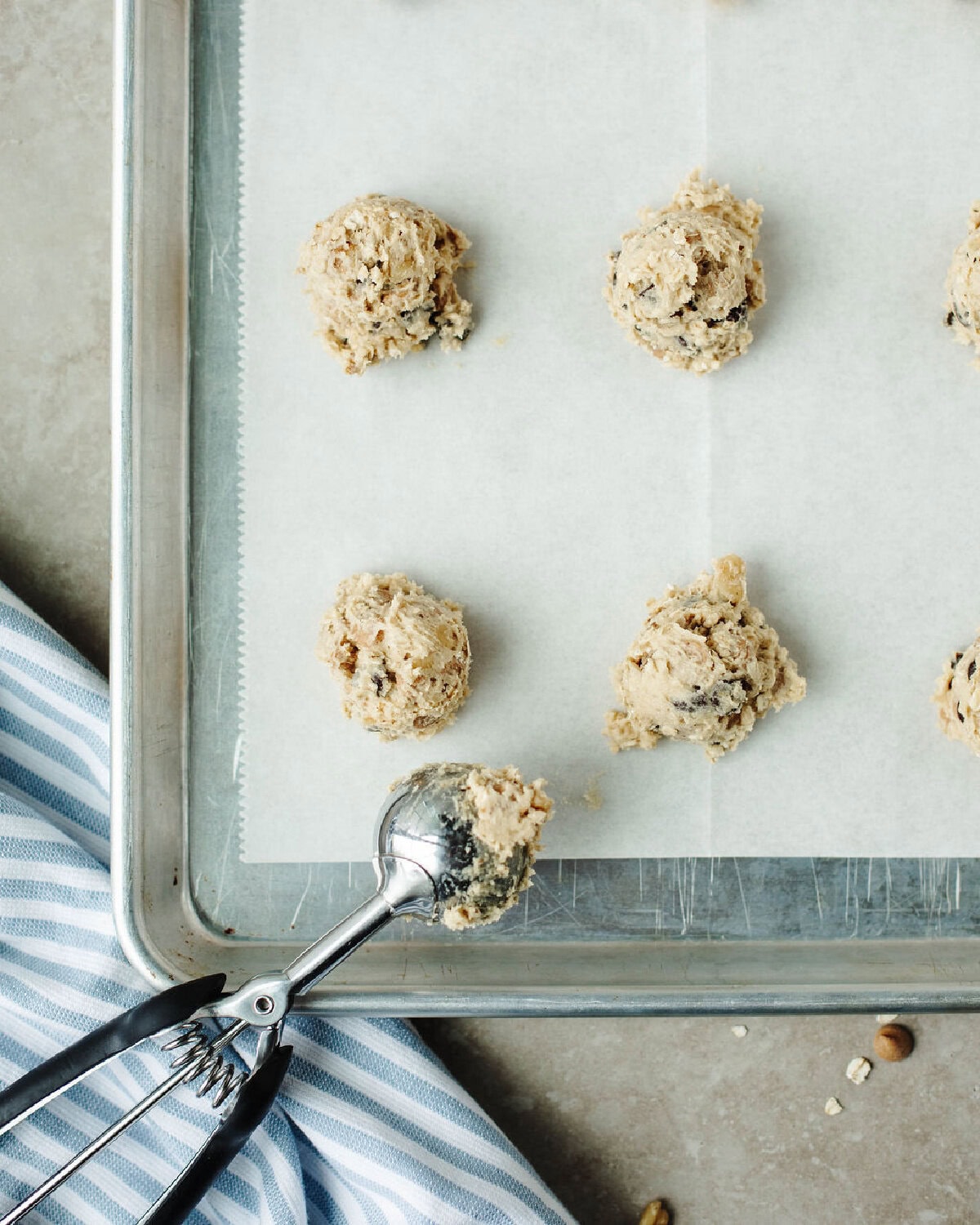Scooped silo cookie dough portions on a parchment-lined baking sheet.