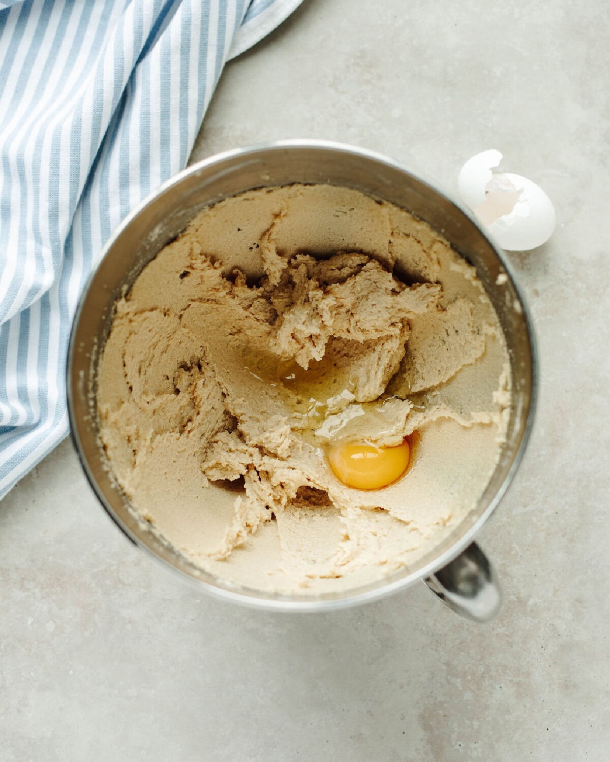 Egg and vanilla extract folded into creamed butter and sugar in a mixing bowl.