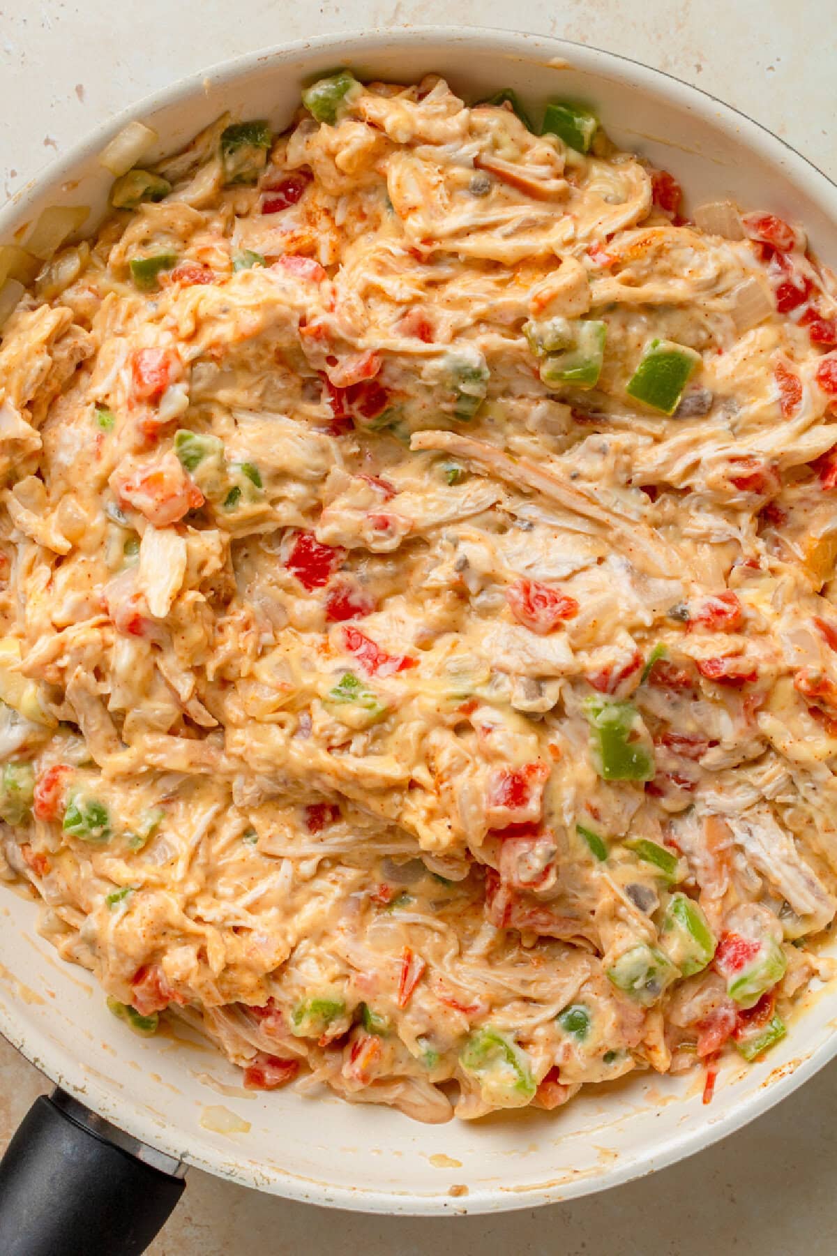 creamy rotel chicken mixture with soup and spices in skillet.