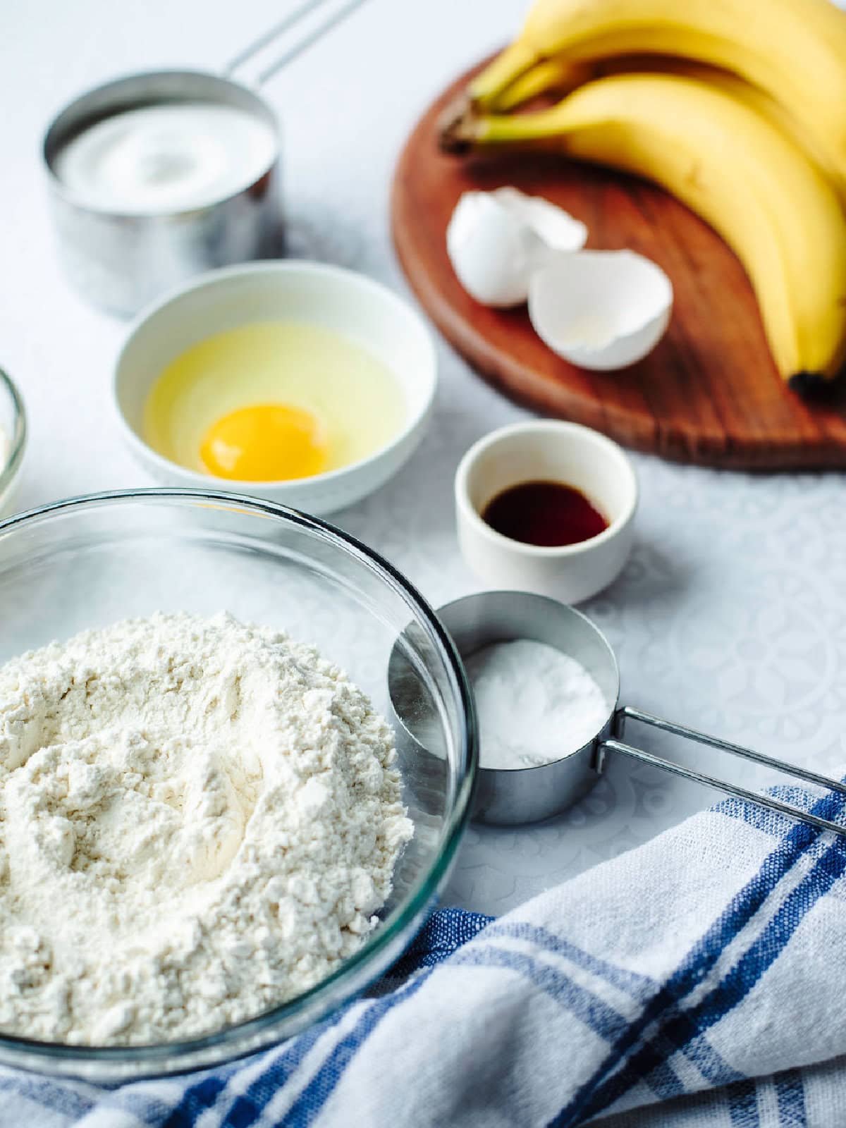 Banana bread batter ingredients mixed in a glass bowl.